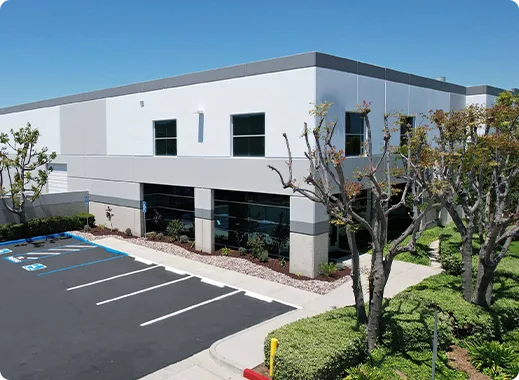 Modern commercial building with parking lot, trees, and clear blue sky. Ideal for businesses like Hygger Aquarium.