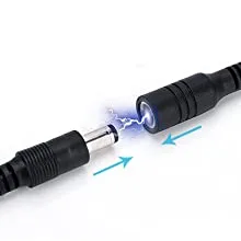 Close-up of two black audio jacks connected with blue spark effect, showing electrical contact.