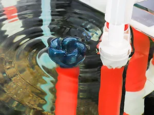 Hygger aquarium with blue water feature and red pipes creating ripples in the water
