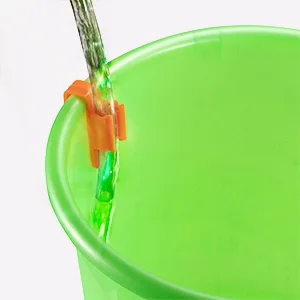 Green plastic cup with water pouring in, featuring a green and orange clip for easy pouring control