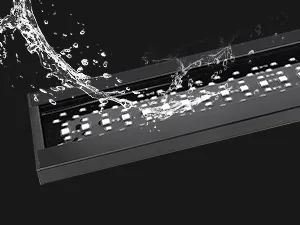 Modern black hygger aquarium with water splashing over its sleek surface, showcasing clean design and water features.